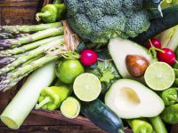 Organic vegetables on rustic dark wood background.Vegan food concept. Green veggies.